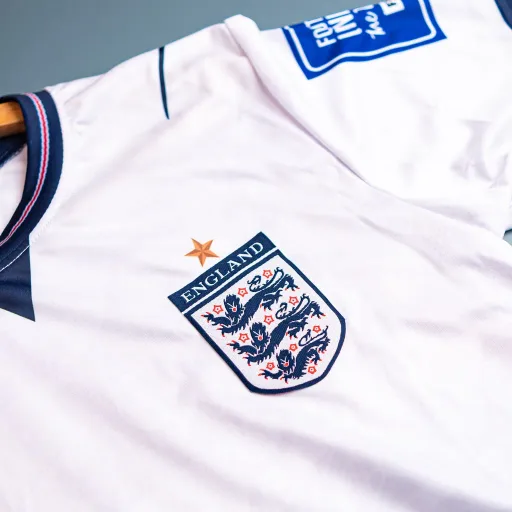 Patch lambang Inggris pada jersey putih